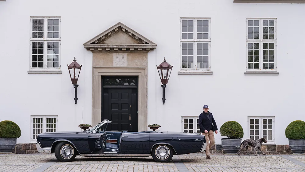 
Anders Kirk Johansen med sin Lincoln Continental cabriolet från 1967 och sin Old Danish Pointer, Pippi, utanför huvudhuset på sin egendom, Rohden Gods
Foto: Tom Parker